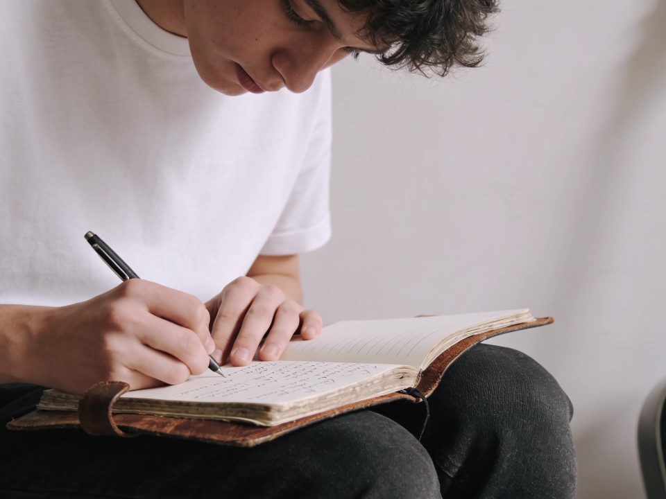 jeune musicien assis griffonnant des paroles sur carnet