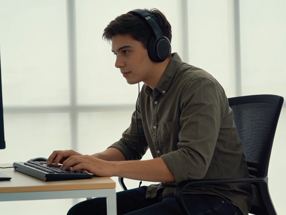 jeune producteur casque sur les oreilles devant ordinateur