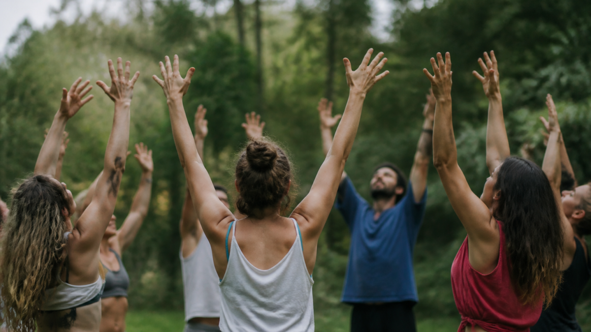 Groupe danseurs en cercle levant bras vers haut ensemble