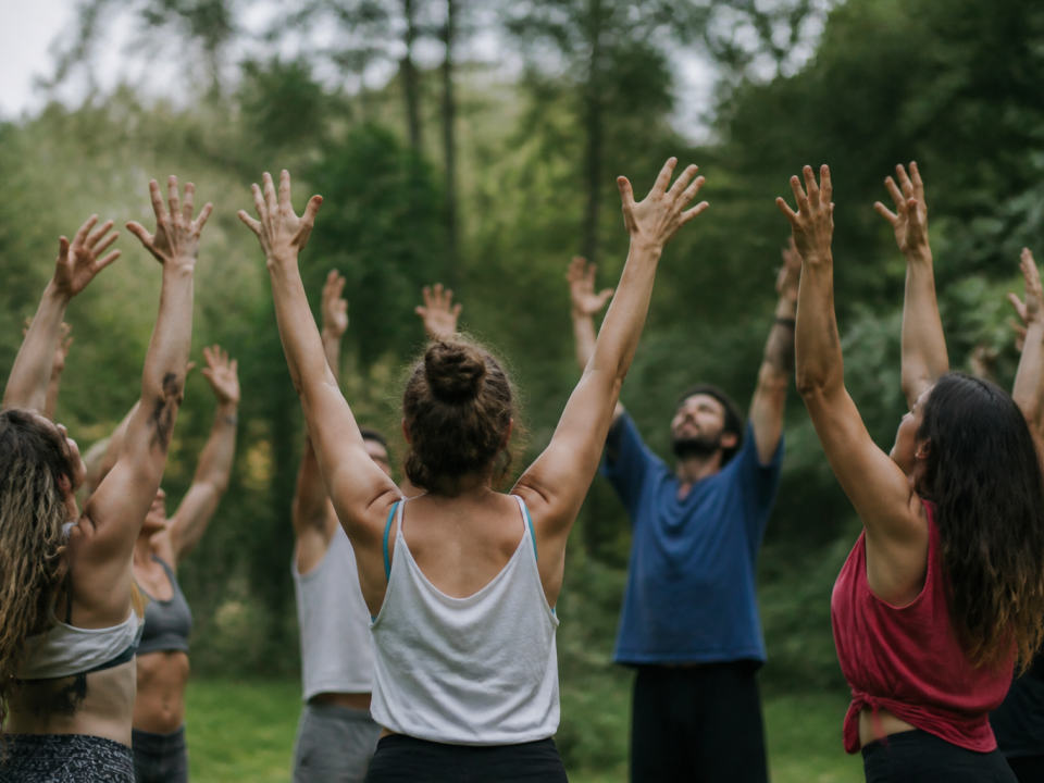Groupe danseurs en cercle levant bras vers haut ensemble