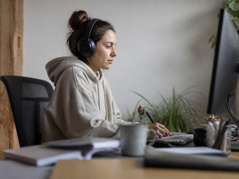 Personne assise a un bureau ecoutant musique casque sur les oreilles