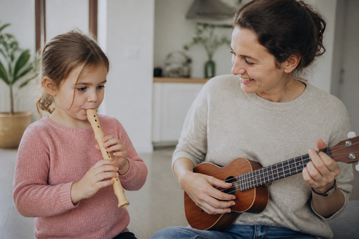 Enfant jouant flute bec, adulte avec ukulele souriant