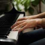 Mains positionnees sur clavier de piano noir et blanc