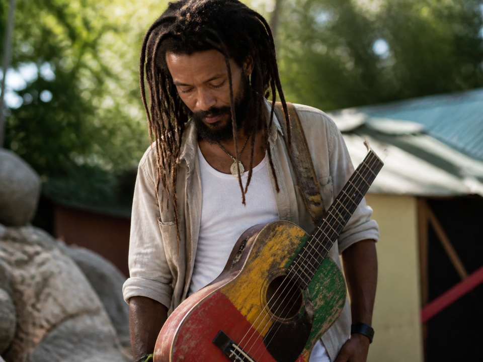 Musicien avec guitare reggae portée en bandouliere