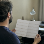 Musicien tenant une partition avec différentes notes espacées