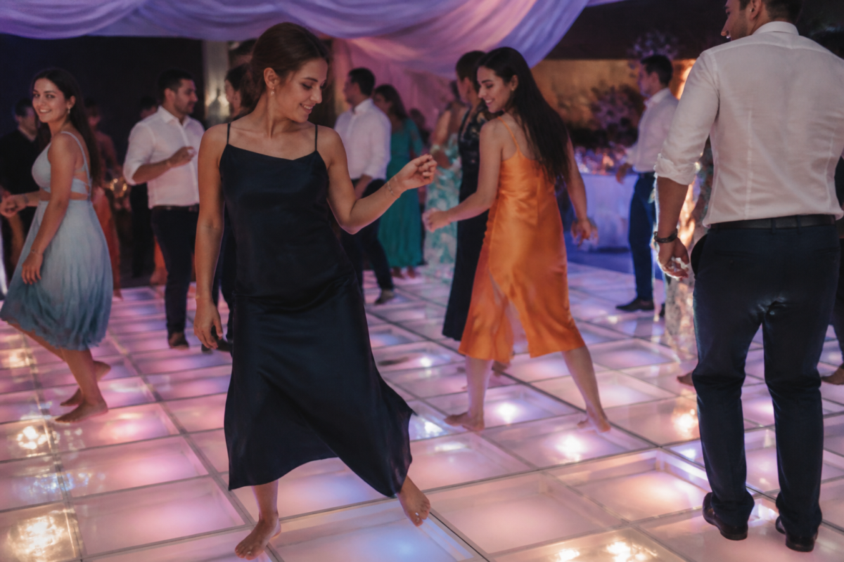 Guests dancing on illuminated floor with colorful ambient lighting