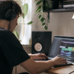 Personne assise devant ordinateur portable jouant musique numerique