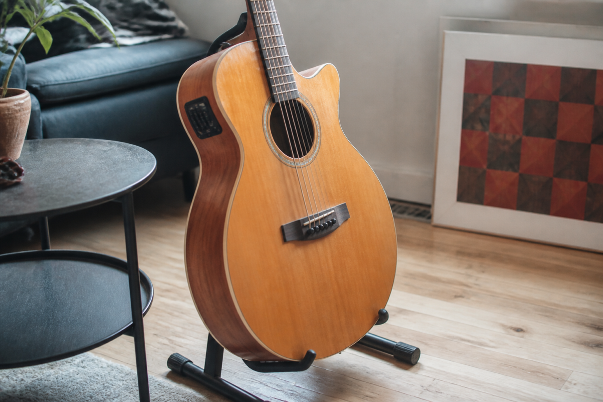 Guitare electro-acoustique bois massif sur stand noir